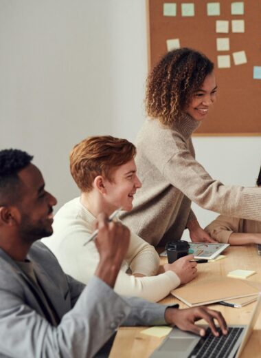 Diverse team collaborating in a meeting, showcasing teamwork and cooperation in a modern workplace.